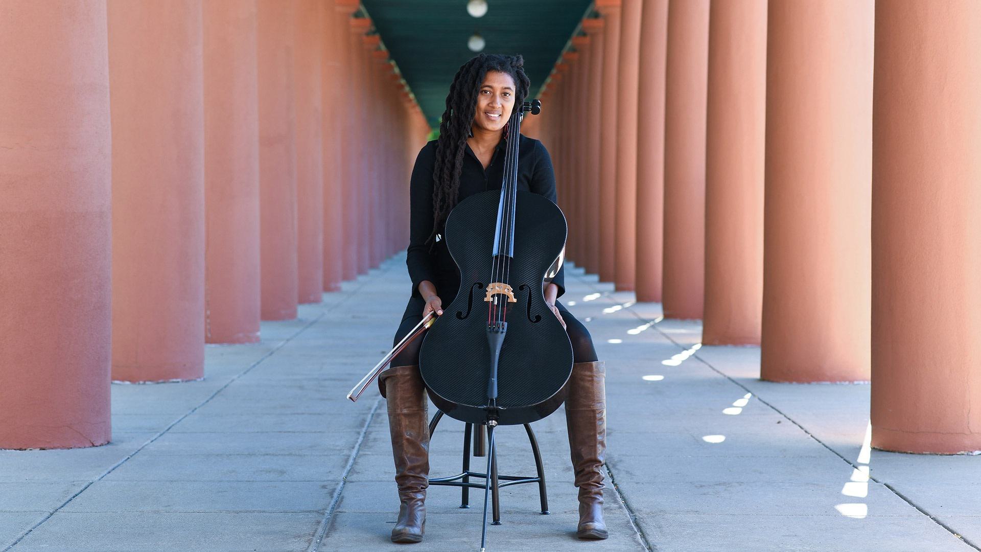 Jazz cellist and composer Tomeka Reid '00 smiling with a cello