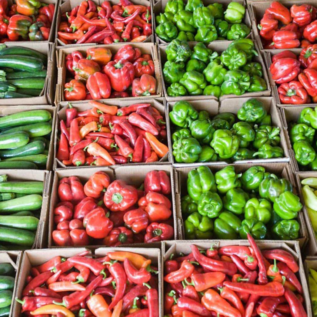 Boxes of red and green peppers and vegetables