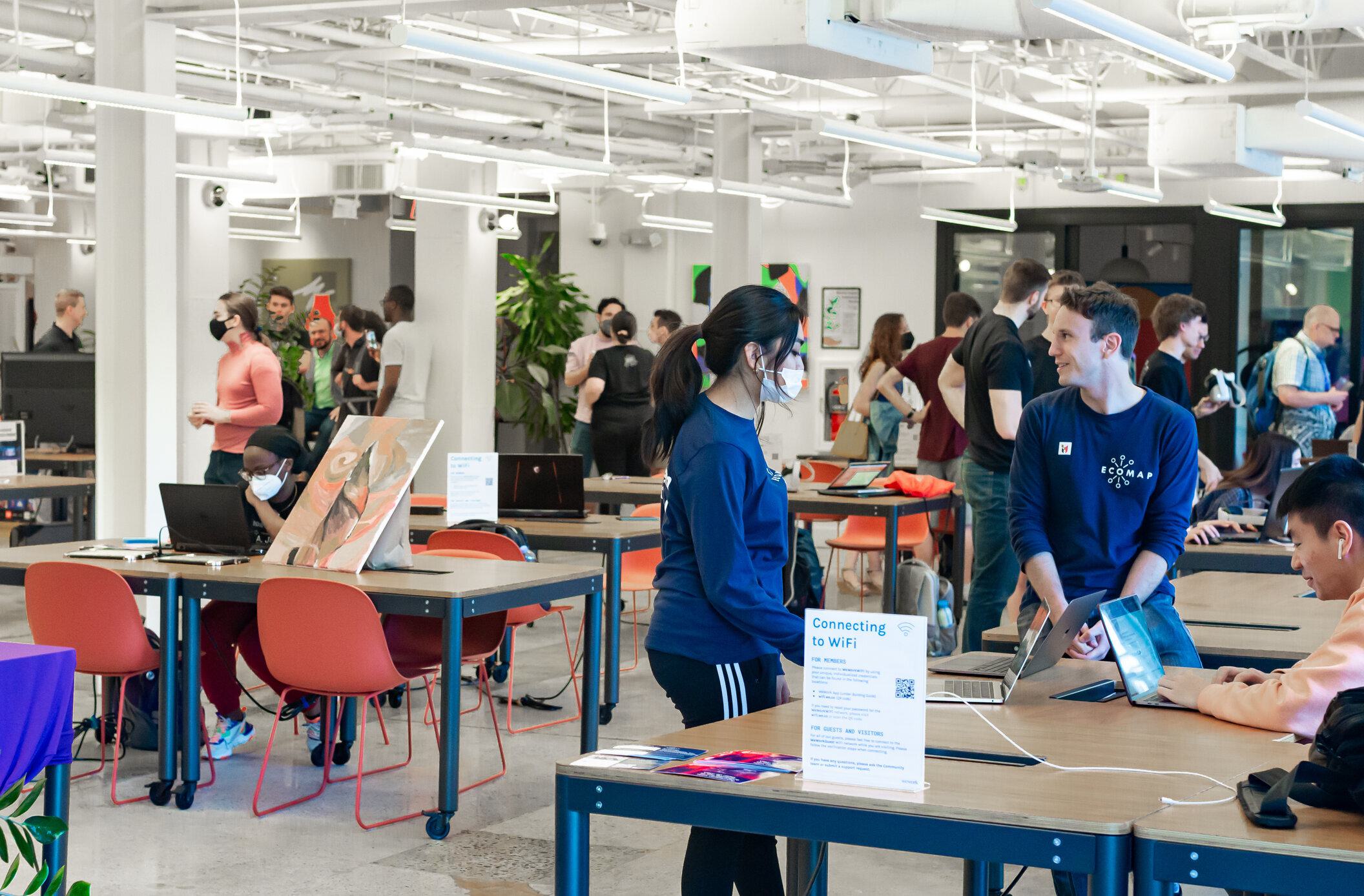 Attendees of the Innovate Maryland Art+Tech Expo visit various extended reality artists and vendors showcasing their projects within the WeWork.