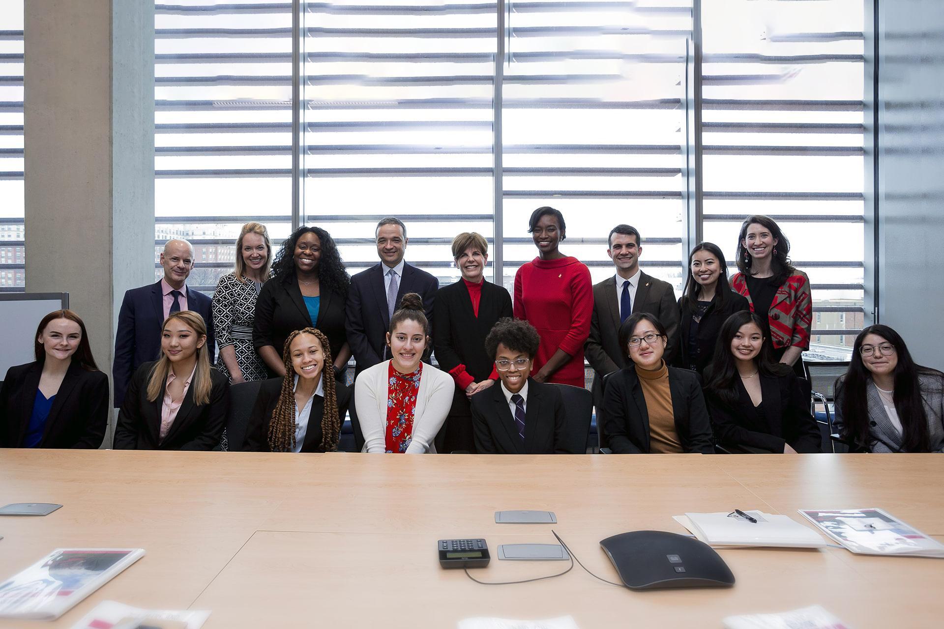 Maryland Promise Scholarship Program honors sit and stand together behind a large conference table for a group photo, all dressed to impress in their professional best