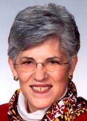 Full color photo of Nancy Kopp smiling wearing a red top and state of Maryland scarf.